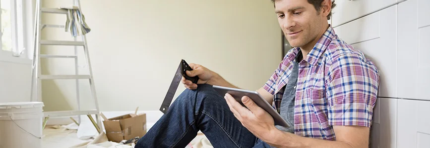 Person betrachtet Tablet beim Heimwerken